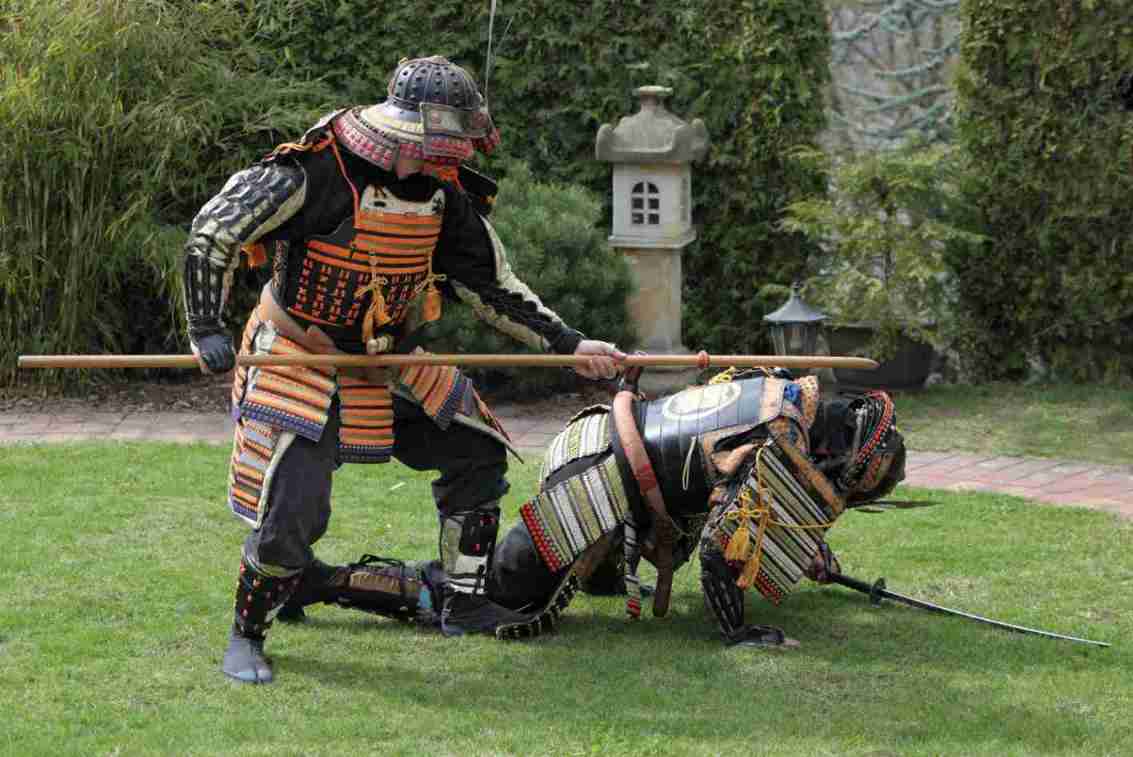 Personas con cosplay de guerreros samurái actuando